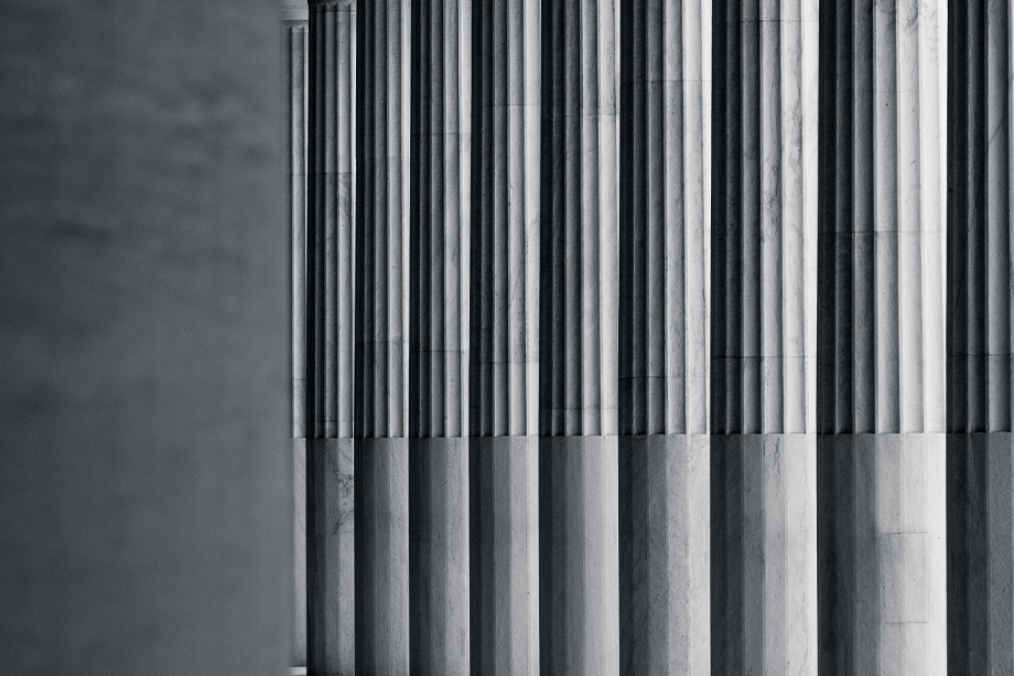 Monochrome photo of fluted classical columns with strong shadows