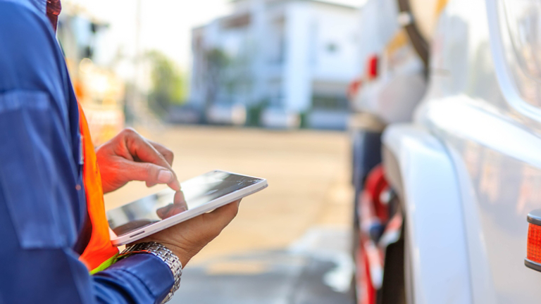 Truck drivers hand holding tablet checking the product list.