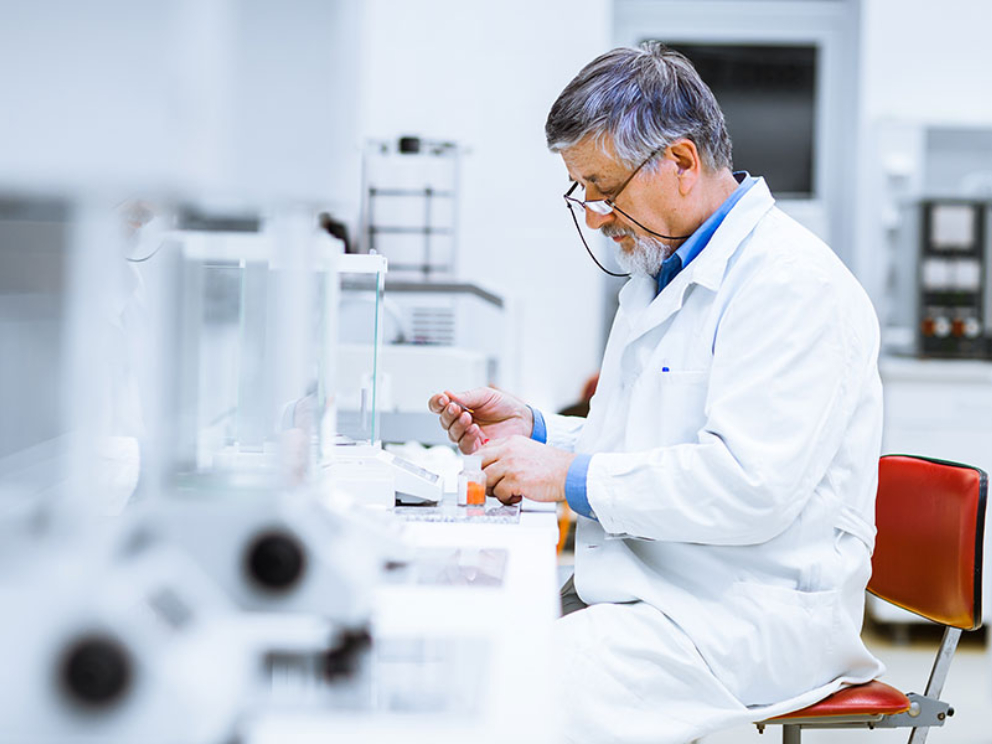 Senior male researcher carrying out scientific research in a lab (shallow DOF; color toned image)