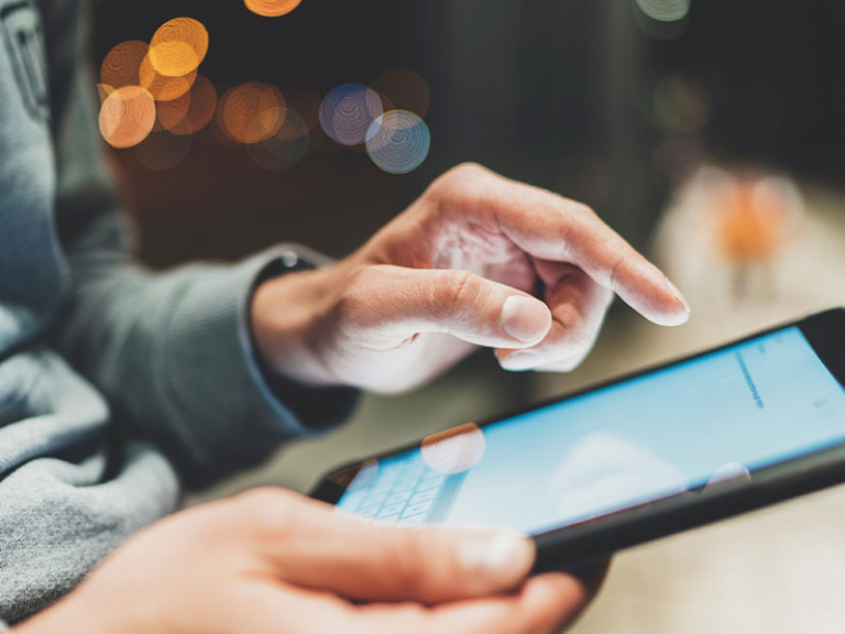 Medium shot of female technician working on a tablet in a data center full of rack servers running diagnostics and maintenance on the system