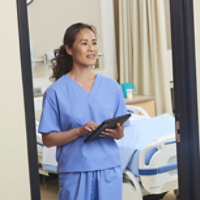 Nurse in Hospital Room with Tablet