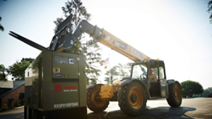 A skid steer loader delivers a Trane Rental Services commercial HVAC unit, which comes with 24/7 technical support.