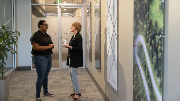 Two female employees talking in hallway