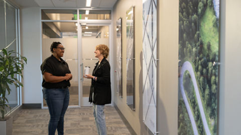 Two female employees talking in hallway