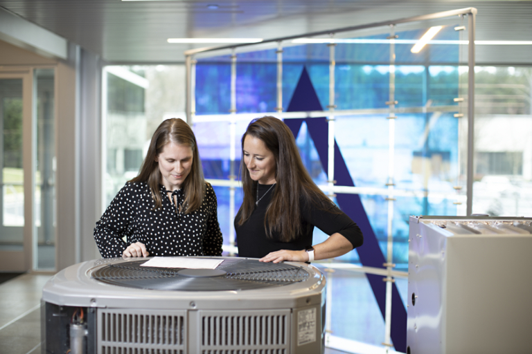 Two employees looking at hvac unit inDavidson