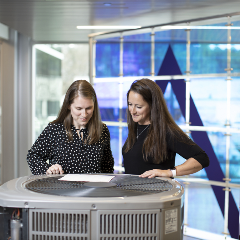 Two employees looking at hvac unit inDavidson