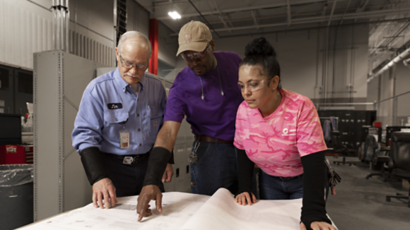 Three employees reviewing plans in Columbia