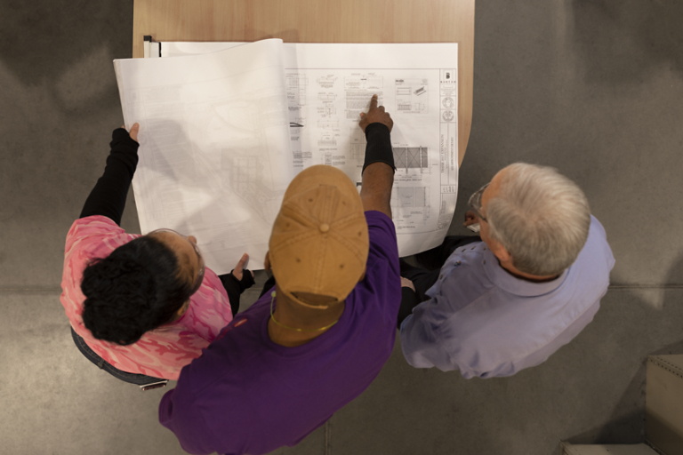 Three employees reviewing plans together in Columbia