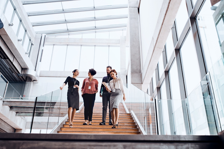 Group of young business people walking down the stairs