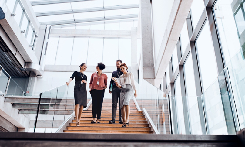 Group of young business people walking down the stairs