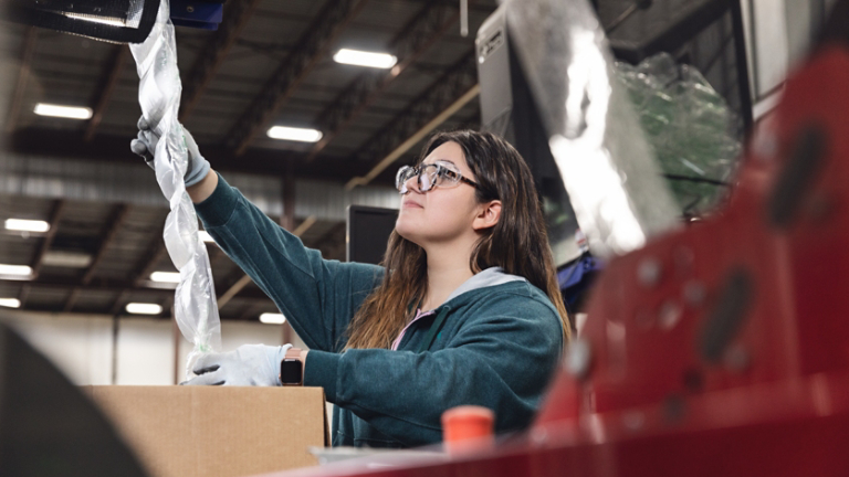 Factory worker reaching for product