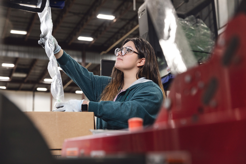 Factory worker reaching for product