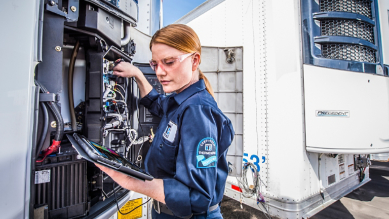 Female Certi-Tech service technician servicing a TRU with tablet