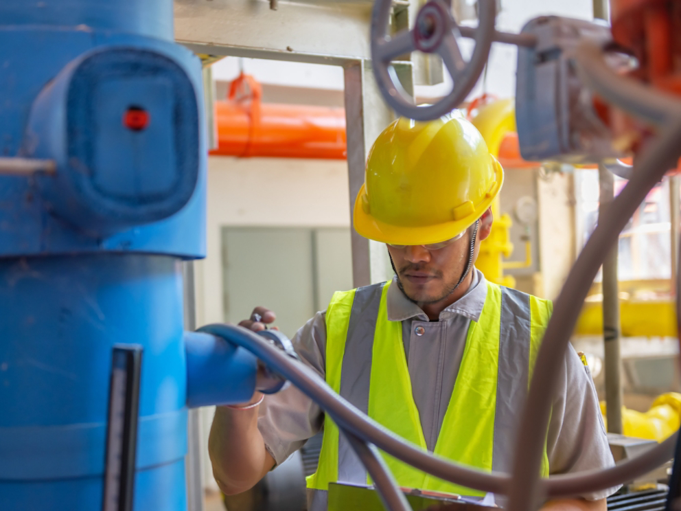 Asian engineer wearing glasses working in the boiler room,maintenance checking technical data of heating system equipment,Thailand people