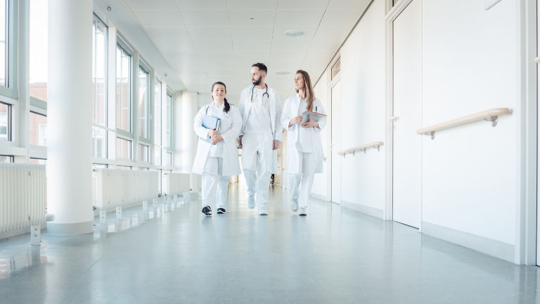 Doctors, two women and a man, in hospital