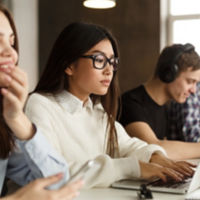 Concentrated international classmates preparing for exams in library