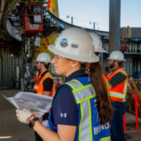 Chrystelle Le Roux on-site with building plans