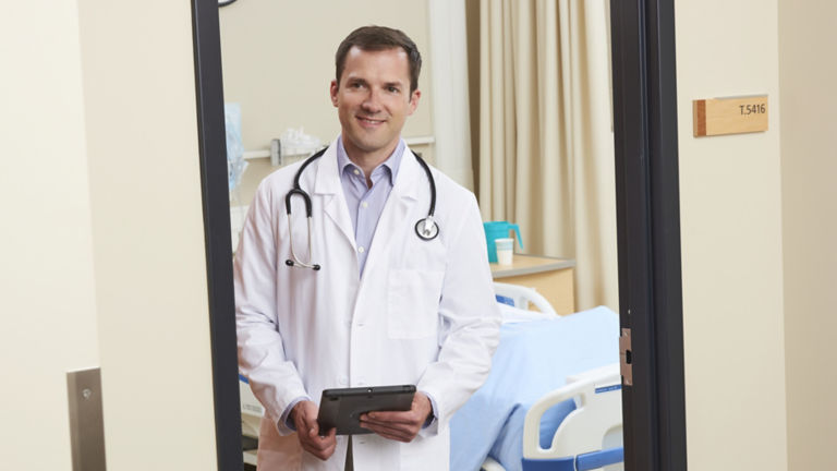 Doctor in Hospital Room with Tablet