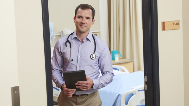 Doctor in Hospital Room with Tablet