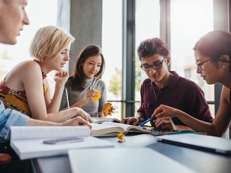Diverse group of students studying at library