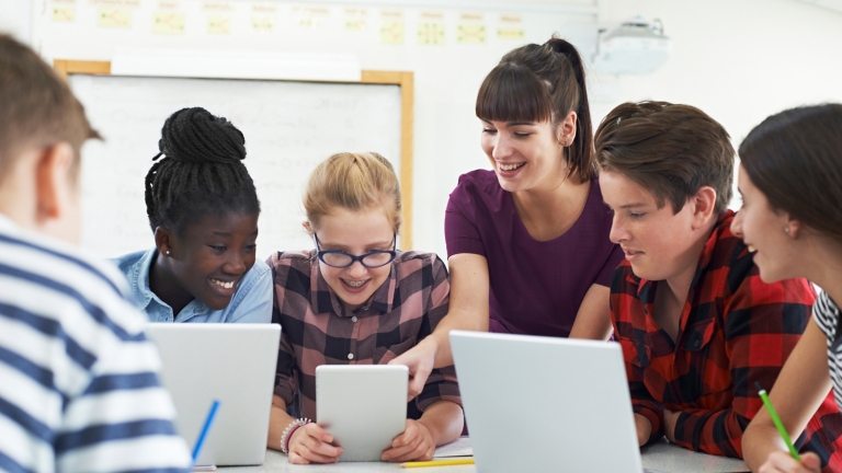 Teenage Students With Teacher In IT Class