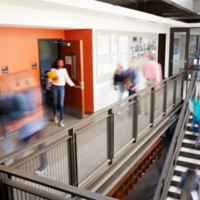 Busy High School Corridor During Recess With Blurred Students And Staff