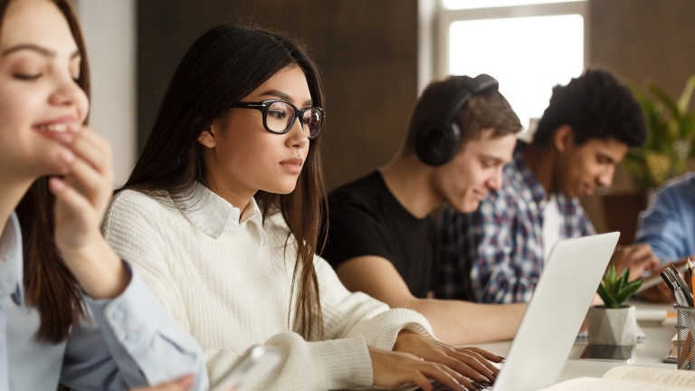 Concentrated international classmates preparing for exams in library