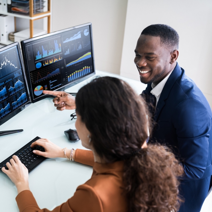 Two Businesspeople Examining Graph On Computer