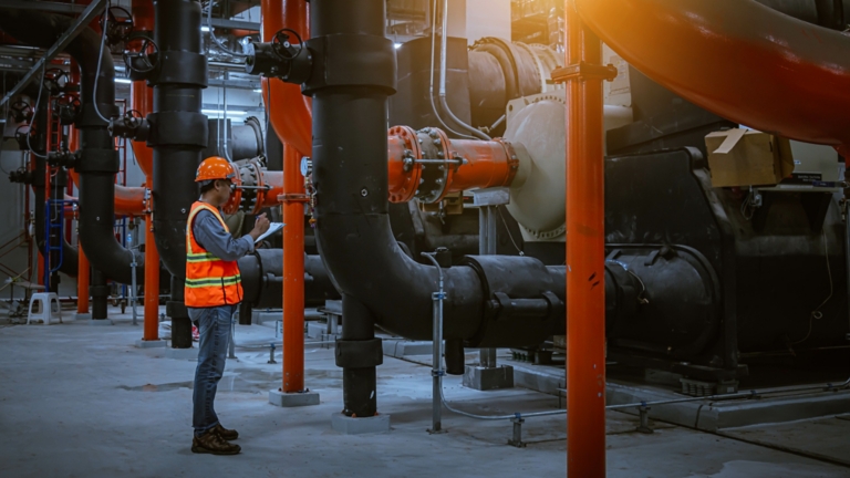 A engineer under checking the industry cooling tower air conditioner is water cooling tower air chiller HVAC of large industrial building to control air system.