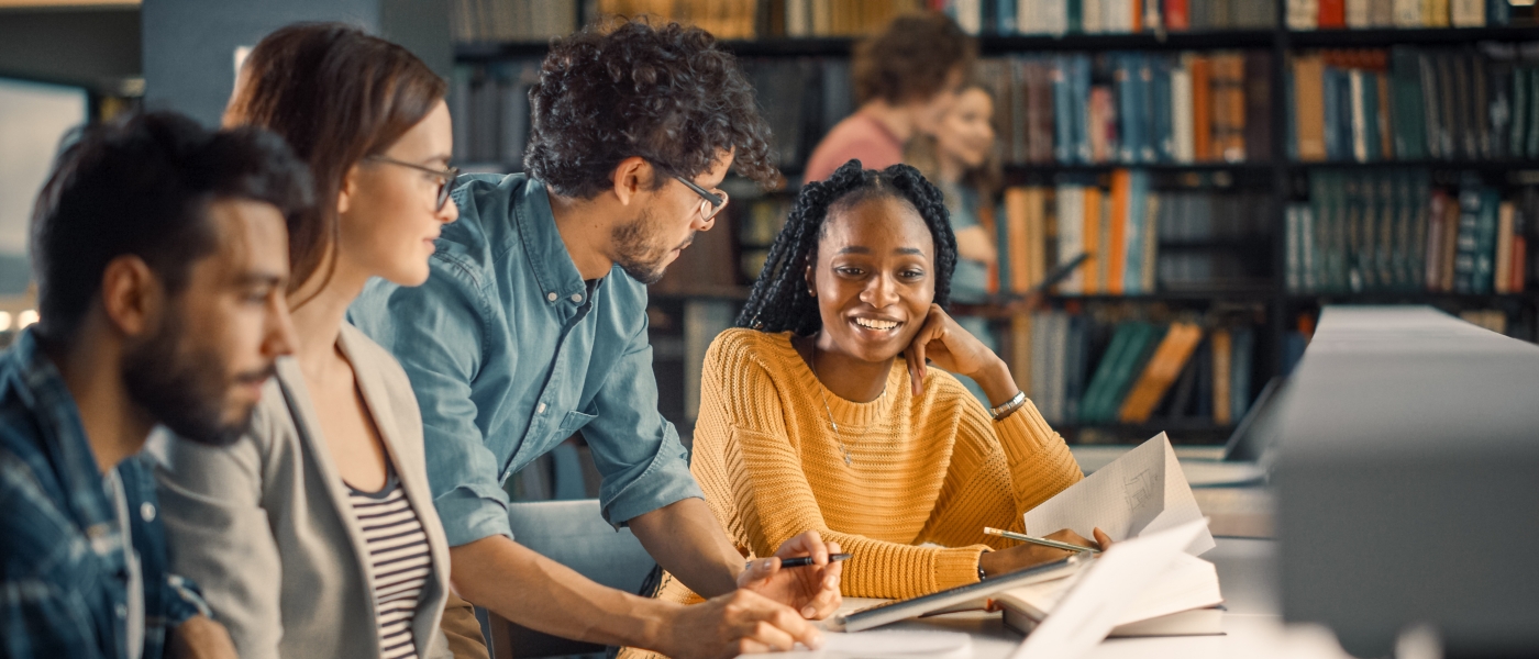 University Library: Diverse Group of Gifted Students Have Discussion, use Laptop, Prepare for Exams Together, Helping, Researching Subjects for Paper Assignment. Happy Young People Study for Future