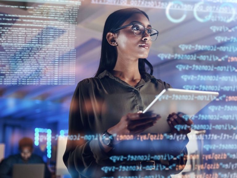 Medium shot of female technician working on a tablet in a data center full of rack servers running diagnostics and maintenance on the system