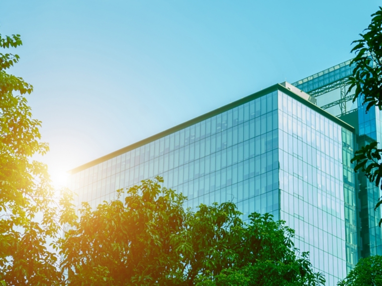 Environmentally friendly office building a sustainable glass building with trees reduces heat and carbon dioxide. Office buildings with a green environment save energy and allow employees to relax.