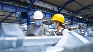 Executive and worker in production factory 