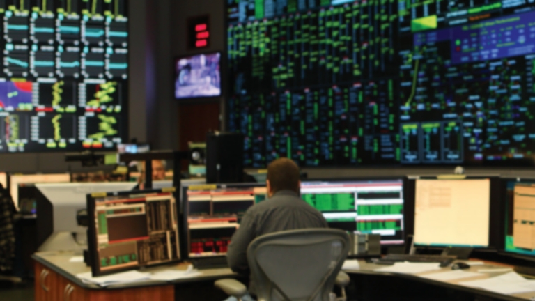 man monitoring data on multiple screens