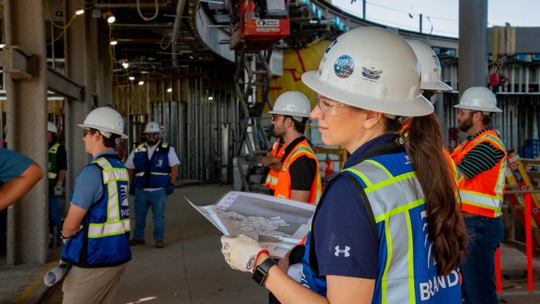 Chrystelle Le Roux on-site with building plans